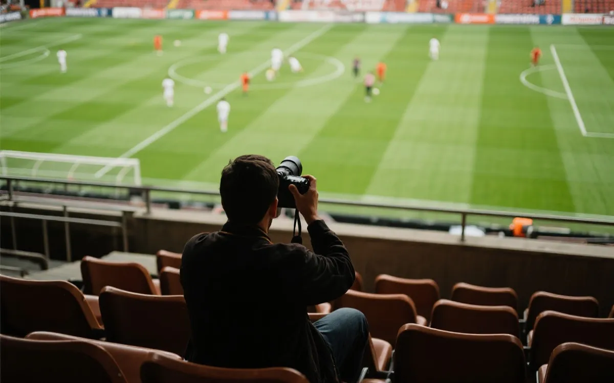 球场看台上摄影者对准绿茵场取景，画面干净、层次分明